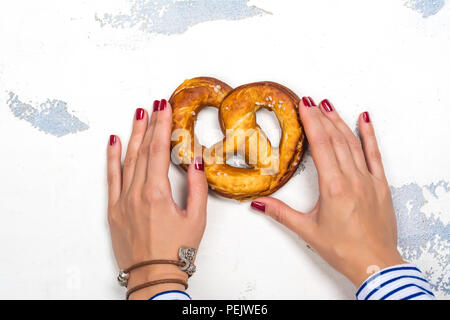 Bretzel bavarois dans les mains de womans, concept équitable Oktoberfest Banque D'Images