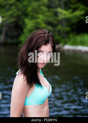 Portrait d'une jolie jeune femme posant devant un lac. Banque D'Images