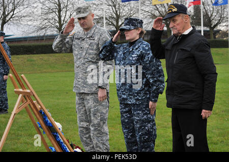 De gauche, de l'armée américaine le Colonel Mark Kjorness, U.S. Africa Command joint intelligence directeur, matelot de la Marine de Sydney, USAFRICOM, analyste de la division et survivant de Pearl Harbor, ancien Marine Sgt. John Egan, saluer une couronne après la mise à l'honneur des victimes de Pearl Harbor Pearl Harbor durant la 74e cérémonie de commémoration à RAF Molesworth, Royaume-Uni, 7 décembre 2015. En plus du dépôt de gerbes, la cérémonie comprenait le jeu de tarauds, un trois-volley saluer par la garde d'honneur et 423rd un survol aérien effectué par la 48e Escadre de chasse F-15 Eagle pilotes. (U.S. Photo de l'Armée de l'air par le sergent. Ashl Banque D'Images