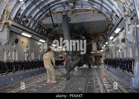 Régiment de cavalerie lourde 3-6 soldats déployés à partir de Fort Bliss, Texas, le travail d'aller de l'un des deux hélicoptères Apache d'un C-17 Globemaster III à Al Udeid Air Base, Qatar, 13 déc. Le C-17, qui est déployé à partir de la 62e Escadre de transport aérien à Joint Base Lewis-McChord, dans l'État de Washington, a livré les hélicoptères. Les hélicoptères devraient prendre part à la parade de la Fête nationale du Qatar annuel fixé pour le 18 décembre. (U.S. Air Force photo de Tech. Le Sgt. James Hodgman/libérés) Banque D'Images