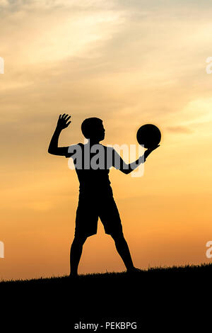 La silhouette du concept photo d'un jeune athlète s'reeady pour servir un terrain de volley-ball. Banque D'Images