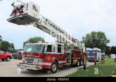 Les membres du grand public visite d'un camion d'incendie organisé par l'affichage Fort McCoy (Wisconsin) Direction des services d'urgence le 7 août 2018, dans le cadre d'une soirée événement à Tomah, Wisconsin (Etats-Unis) Des centaines de personnes ont assisté à l'événement, qui a eu lieu au Parc du Sparta Winnebago. Introduit en 1984 par l'Association nationale de la ville, regarder la nuit dehors est un organisme de prévention du crime qui travaille en collaboration avec des milliers de groupes de surveillance de la criminalité et les organismes d'application de l'ensemble du pays. (U.S. Photo de l'Armée de Scott T. Sturkol, Public Affairs Office, Fort McCoy, Wisconsin) Banque D'Images