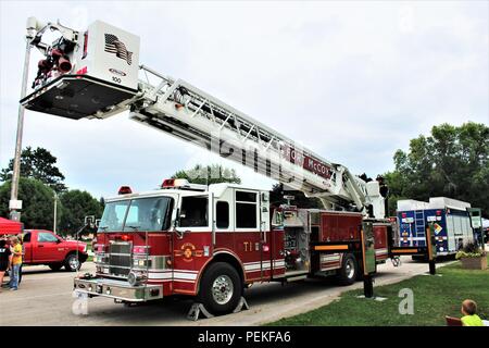 Les membres du grand public visite d'un camion d'incendie organisé par l'affichage Fort McCoy (Wisconsin) Direction des services d'urgence le 7 août 2018, dans le cadre d'une soirée événement à Tomah, Wisconsin (Etats-Unis) Des centaines de personnes ont assisté à l'événement, qui a eu lieu au Parc du Sparta Winnebago. Introduit en 1984 par l'Association nationale de la ville, regarder la nuit dehors est un organisme de prévention du crime qui travaille en collaboration avec des milliers de groupes de surveillance de la criminalité et les organismes d'application de l'ensemble du pays. (U.S. Photo de l'Armée de Scott T. Sturkol, Public Affairs Office, Fort McCoy, Wisconsin) Banque D'Images