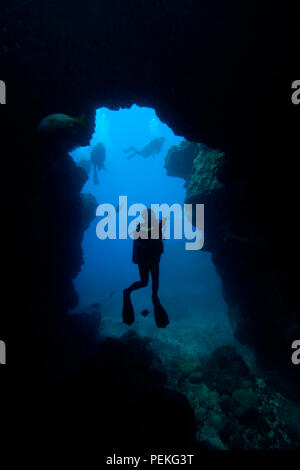 Divers (MR) à une entrée Sheraton Cavern hors de l'île de Kauai, Hawaii. Banque D'Images