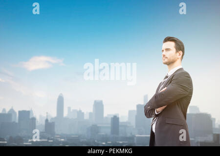 Businessman standing, au-dessus du bâtiment et à l'avant, concept que l'objectif défini, commis et avoir une vision concept avec fond de ciel bleu Banque D'Images