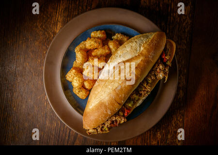 Philly Cheesesteak avec oignons en dés les poivrons et les champignons avec tater-tots Banque D'Images