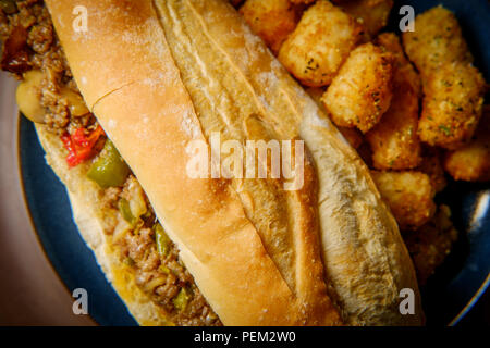 Philly Cheesesteak avec oignons en dés les poivrons et les champignons avec tater-tots Banque D'Images