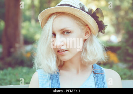 Portrait de beau Shadow of young blond autre modèle fille femme avec des yeux bleu gris, en chapeau de paille à l'arc, à la caméra en Banque D'Images