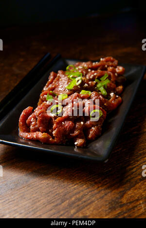 Marinade barbecue coréen raw beef Bulgogi en éclairage sombre moody Banque D'Images