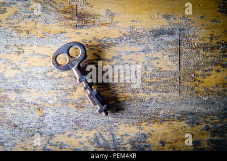 Ancienne clé de squelette sur fond de bois texturé en détresse Banque D'Images