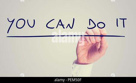 Retro droit d'un homme d'écrire un message de motivation - Vous pouvez le faire - sur une interface virtuelle ou l'écran avec un marqueur comme un signe d'encouragement, avec Banque D'Images