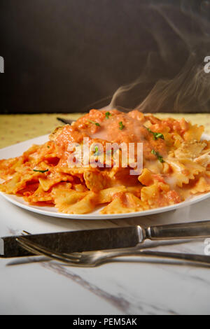 Pâtes Farfalle Bow tie dans la vodka crème de poulet grillé sauce tomate et petits pois Banque D'Images