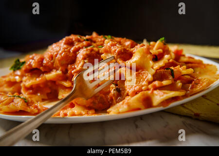 Pâtes Farfalle Bow tie dans la vodka crème de poulet grillé sauce tomate et petits pois Banque D'Images