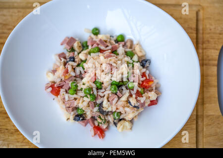 Salade de riz italien ou le riz froid dans une assiette blanche sur une planche à découper Banque D'Images