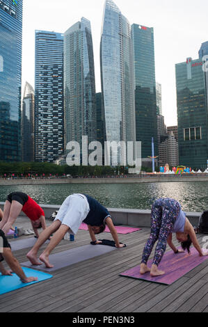 21.12.2017, Singapour, République de Singapour, en Asie - les participants d'une classe de yoga sont vus faire leur pratique du yoga à Marina Bay. Banque D'Images