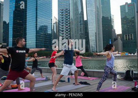 21.12.2017, Singapour, République de Singapour, en Asie - les participants d'une classe de yoga sont vus faire leur pratique du yoga à Marina Bay. Banque D'Images