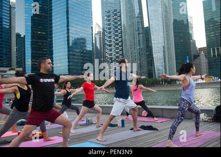 21.12.2017, Singapour, République de Singapour, en Asie - les participants d'une classe de yoga sont vus faire leur pratique du yoga à Marina Bay. Banque D'Images