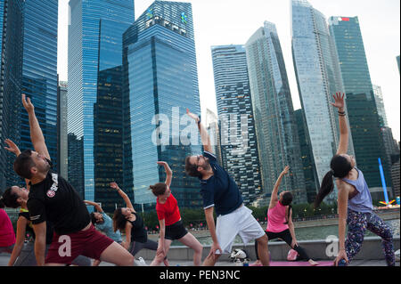 21.12.2017, Singapour, République de Singapour, en Asie - les participants d'une classe de yoga sont vus faire leur pratique du yoga à Marina Bay. Banque D'Images