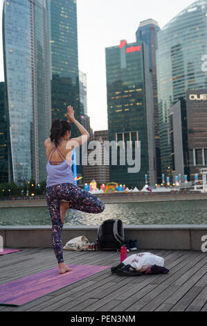 21.12.2017, Singapour, République de Singapour, en Asie - Une participante d'un cours de yoga est considéré faire son yoga à Marina Bay. Banque D'Images