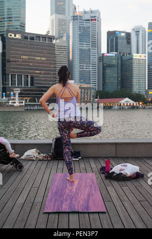 21.12.2017, Singapour, République de Singapour, en Asie - Une participante d'un cours de yoga est considéré faire son yoga à Marina Bay. Banque D'Images