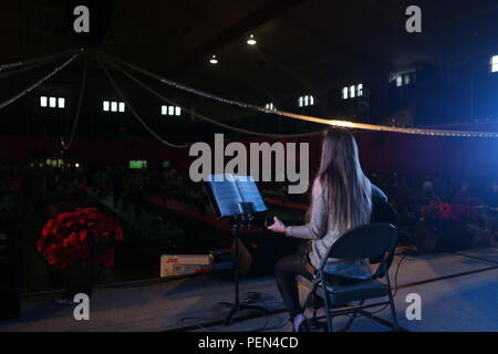 Un musicien de la région joue la musique de Noël pour accueillir les clients de la II Marine Expeditionary Force Groupe party de Noël annuel de l'Administration centrale à mesure qu'elles entreront en Goettge Field House à Camp Lejeune, N.C., 13 décembre 2015. Marines, marins, famille et amis se sont réunis pour prendre part à l'appartement de festivités au cours de l'événement. II MHG fournit la commande prête au combat et de contrôle, de communication, de renseignement, de sécurité, des armes, des conseillers de liaison, de soutien administratif et logistique aux capacités II MEF afin de permettre à ses fonctions de combat militaire, pour l'ensemble des Banque D'Images