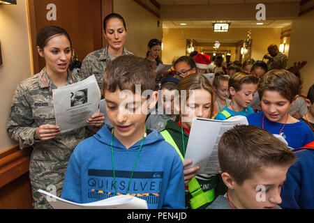 Airman Senior Dana Rhoads, gauche et Tech. Le Sgt. Kelly Howe, à droite, à la fois avec 177e Escadre de chasse, New Jersey Air National Guard, chanter avec quatrième année de l'École de la mer à Linwood, N.J., au cours de la 15e édition annuelle de la maison de vacances "ongfest» au New Jersey Veterans Memorial Home à Vineland, N.J., le 16 Déc., 2015. Les 80 élèves de quatrième rejoint le 16 aviateurs à chanter des chants de Noël à l'accueil pendant l'événement. (U.S. Air National Guard photo par le Sgt. Mark C. Olsen/libérés) Banque D'Images