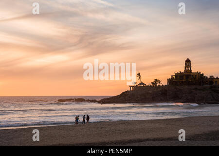 Un groupe d'amis marche sur Cerritos Beach au coucher du soleil. Banque D'Images