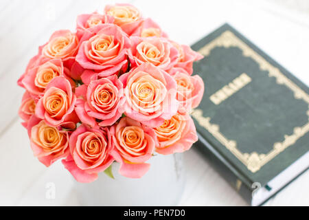 Roses dans une boîte ronde et la Bible. Belles roses roses sur un fond de bois blanc. Belles roses et la Bible. Roses dans une boîte à chapeau Banque D'Images