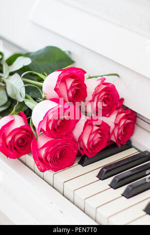 Roses rouges de luxe sur un piano. Bouquet de roses rouges et des touches de piano Banque D'Images