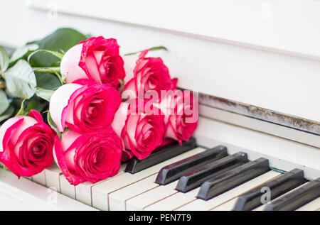 Roses rouges de luxe sur un piano. Bouquet de roses rouges et des touches de piano Banque D'Images