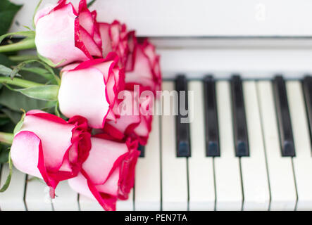 Roses rouges de luxe sur un piano. Bouquet de roses rouges et des touches de piano Banque D'Images