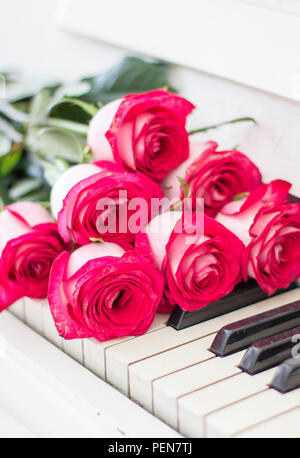 Roses rouges de luxe sur un piano. Bouquet de roses rouges et des touches de piano Banque D'Images