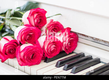 Roses rouges de luxe sur un piano. Bouquet de roses rouges et des touches de piano Banque D'Images