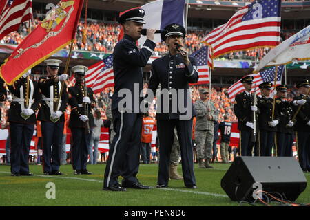 Air Force Academy les membres de la bande d'un membre de la 1re classe Jamie Teachenor et Tech. Le Sgt. Krista Joyce chanter l'hymne national dans les cérémonies d'ouverture pour le salut au Service game entre les Denver Broncos et Kansas City Chiefs à Sports Authority Field à Denver, le 15 novembre 2015. Le salut au Service game est un jeu qui a eu lieu chaque saison NFL de reconnaître le passé et le présent les membres en service de chaque branche de service. (U.S. La Garde nationale de l'armée photo par le Sgt. Ray R. Casares/libérés) Banque D'Images