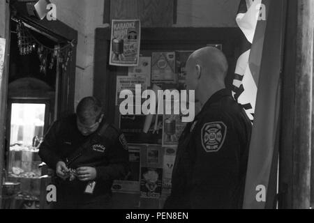 Le s.. Russell Vidler, 98e Division de la formation (IET) Drill Sergeant de l'année, et Peter Snell, un pompier avec le Service des incendies d'Ithaca, regardez comme James papule, le lieutenant shift, tente de trouver la touche droite pour fixer la porte d'une entreprise locale à Ithaca, N.Y., 16 décembre 2015. Vidler a travaillé comme pompier à la ville d'Ithaque depuis deux ans maintenant. (U.S. Photo de l'armée par le Sgt. 1re classe Brian Hamilton) Banque D'Images