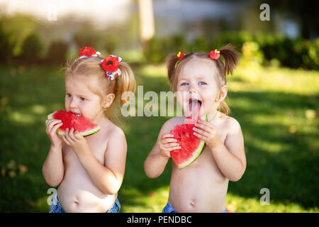 De l'été alimentation saine. Deux happy smiling child eating watermelon en parc. Closeup portrait of cute little girls. Banque D'Images