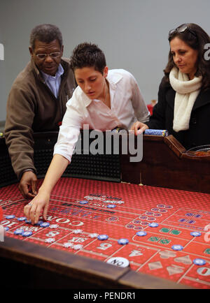 Les membres et les invités de service avec le Siège et l'Escadron placer des paris sur la table d'un jeu de casino au cours de l'escadron, Soirée casino annuel au Marine Corps Air Station Cherry Point, N.C., janv. 8, 2016. L'événement a donné les membres de service, les amis et les familles la possibilité de s'amuser et obtenir concurrentiel. Dès l'entrée à l'événement, chaque invité a été donné de faux billets qui ils ont tourné en aux revendeurs pour des jetons à jouer pour avoir une chance de gagner l'un des dizaines de prix de présence. Banque D'Images