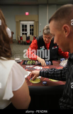 Un pari est placé sur la table en tant que Marines et leurs invités avec le Siège et l'Escadron placer des paris sur les jeux de casino différents au cours de l'escadron, Soirée casino annuel au Marine Corps Air Station Cherry Point, N.C., janv. 8, 2016. L'événement a donné les membres de service, les amis et les familles la possibilité de s'amuser et obtenir concurrentiel. Dès l'entrée à l'événement, chaque invité a été donné de faux billets qui ils ont tourné en aux revendeurs pour des jetons à jouer pour avoir une chance de gagner l'un des dizaines de prix de présence. Banque D'Images