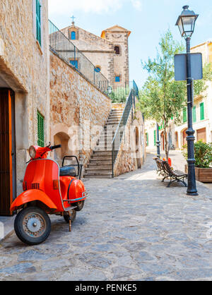 Vintage red scooter stationné dans un village historique espagnol Banque D'Images