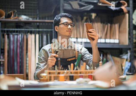 Jeune artisan cuir travaillant en studio Banque D'Images