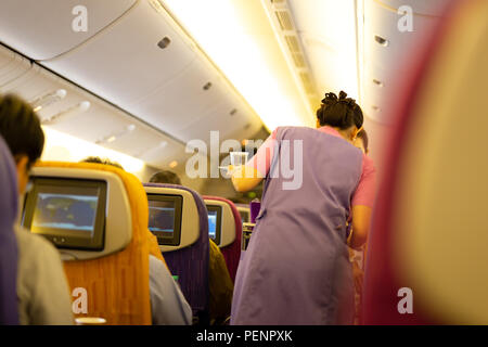 Intérieur de l'avion avec des passagers à bord à bord le service des aliments et boissons. Banque D'Images