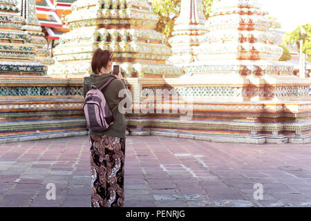 Touristiques non identifiés women taking picture with cell phone visiter temple Thaï en Thaïlande. Banque D'Images