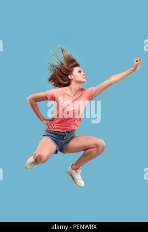 La liberté en déménagement. Déplacez uniquement vers l'avenir. jolie jeune femme sautant et gesticulant contre studio bleu arrière-plan. Shining girl en mouvement ou mouvement. Les émotions humaines et les expressions faciales concept Banque D'Images