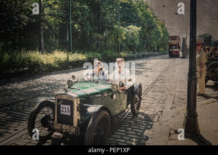 Crich Tramway Village, derbys, 1940 Événement. Scène de rue Vintage & les filles sont dehors pour impressionner la croisière et profiter de leur vintage Austin motor car ! Banque D'Images