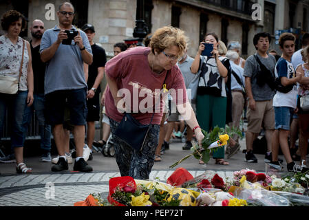 Barcelone, Espagne. 16 août 2018. Une femme met une fleur sur le terrain de Las Ramblas à Barcelone pour rendre hommage aux victimes des attaques terroristes de l'an dernier qui a tué 16 personnes et blessé plus de 120 lorsque deux véhicules s'est écrasé dans la foule. Crédit : Jordi Boixareu/Alamy Live News Banque D'Images