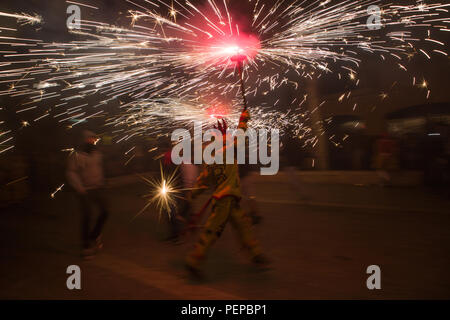 Santander, Espagne, le 16 août, 2018. Un homme marche à travers la place principale avec un pétard dans la main dans la nuit de fête du feu dans la ville de Santander, Espagne. Credit : Gergő Lázár/Alamy Live News Banque D'Images