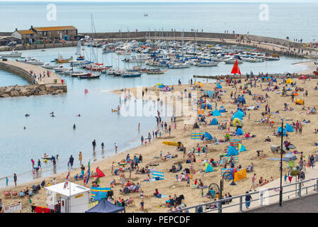 Lyme Regis, dans le Dorset, UK. 17 août 2018. Météo France : les vacanciers affluent à la plage pour profiter d'un matin de petites éclaircies à Lyme Regis. La pittoresque plage de la station balnéaire de Lyme Regis était occupé à nouveau ce matin que les nuages épais est cassée par de longues périodes de lumière du soleil chaude. Credit : Celia McMahon/Alamy Live News. Banque D'Images