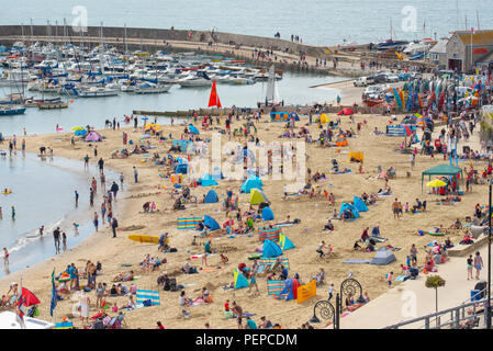 Lyme Regis, dans le Dorset, UK. 17 août 2018. Météo France : les vacanciers affluent à la plage pour profiter d'un matin de petites éclaircies à Lyme Regis. La pittoresque plage de la station balnéaire de Lyme Regis était occupé à nouveau ce matin que les nuages épais est cassée par de longues périodes de lumière du soleil chaude. Credit : Celia McMahon/Alamy Live News. Banque D'Images