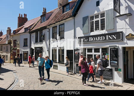 Les touristes les visiteurs dans le centre-ville en été à côté du pub Board Inn Church Street Whitby North Yorkshire Angleterre Royaume-Uni Grande-Bretagne Banque D'Images