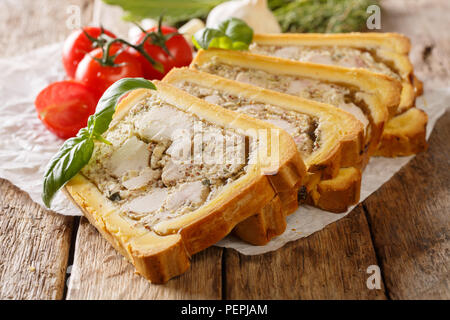 Terrine de poulet dans le pain coupé en morceaux sur la table horizontale. Banque D'Images